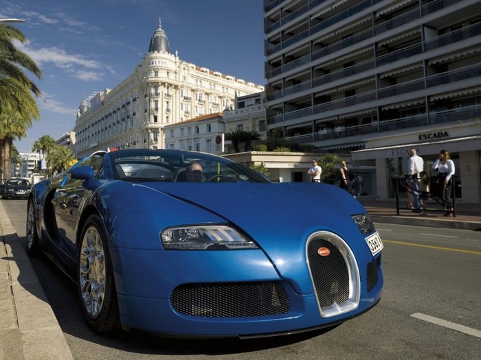 Blue Bugatti Veyron parked on street with Carlton Hotel