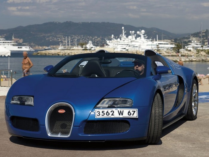 Blue Bugatti Veyron convertible with yachts in background