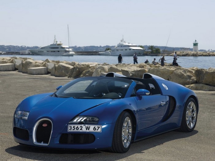Blue Bugatti Veyron convertible parked by the sea with yachts