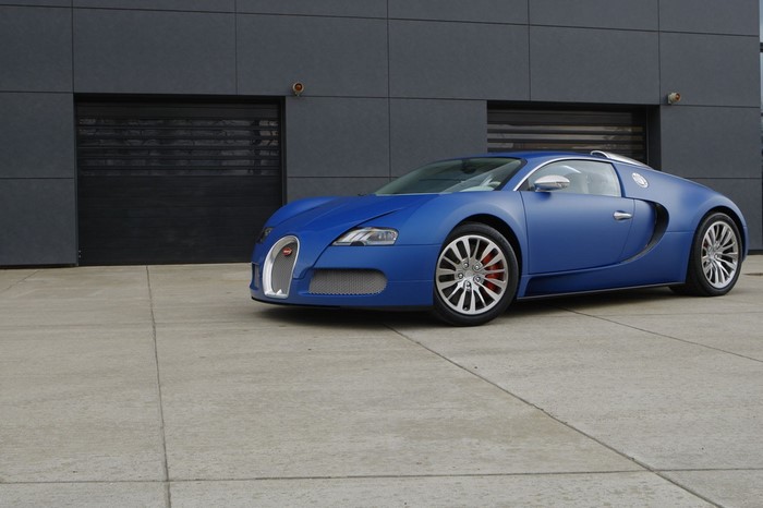 Blue Bugatti Veyron parked in front of a modern building
