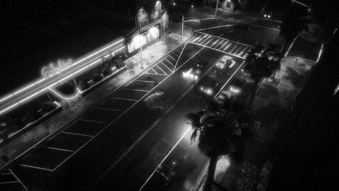 Nighttime street scene with cars and neon sign