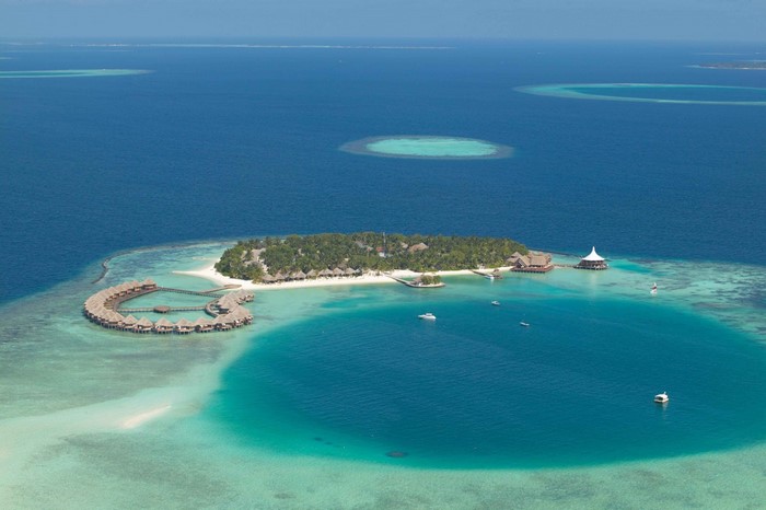Aerial view of a tropical island resort with overwater bungalows