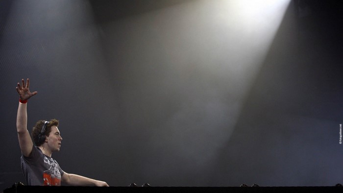 DJ Hardwell performing on stage with spotlight