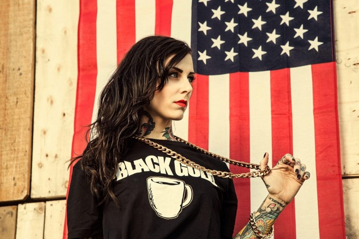 Woman with tattoos in front of American flag