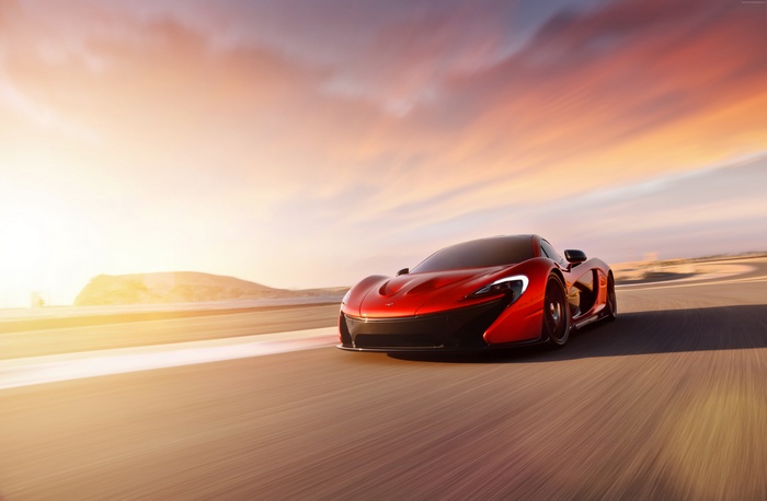 Red McLaren P1 hypercar driving on a road at sunset