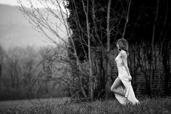 Woman in white dress walking in a field