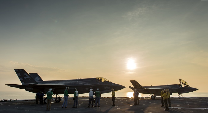 F-35 Lightning II fighter jets on aircraft carrier at sunset