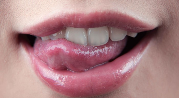 Close up of a person's mouth with tongue sticking out