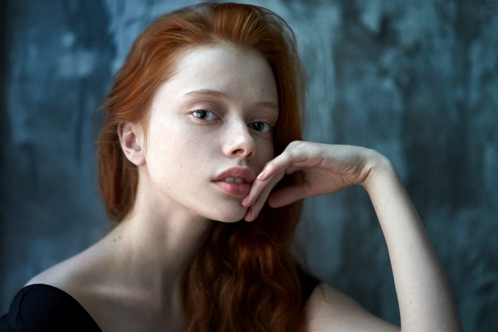 Redhead woman with hand on chin, portrait photography