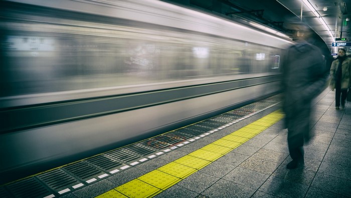 Train in motion at a subway station with blurred people