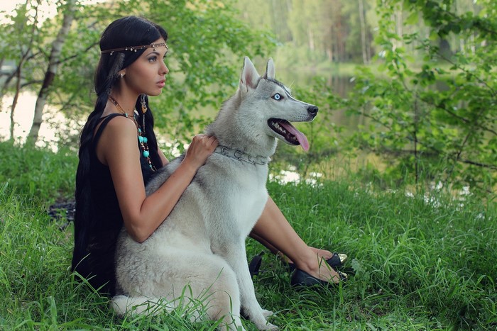 Woman with a husky dog in a forest
