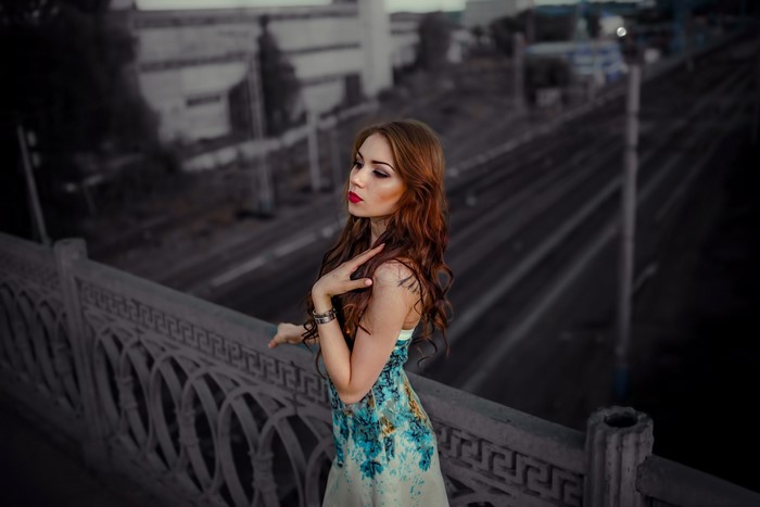 Woman with red hair on a bridge