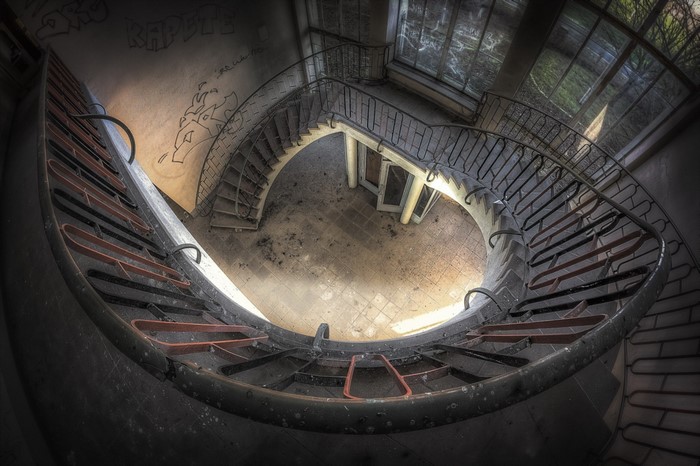 Abandoned building with spiral staircase and graffiti