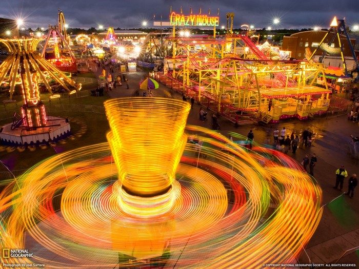 Amusement park rides at night with light trails