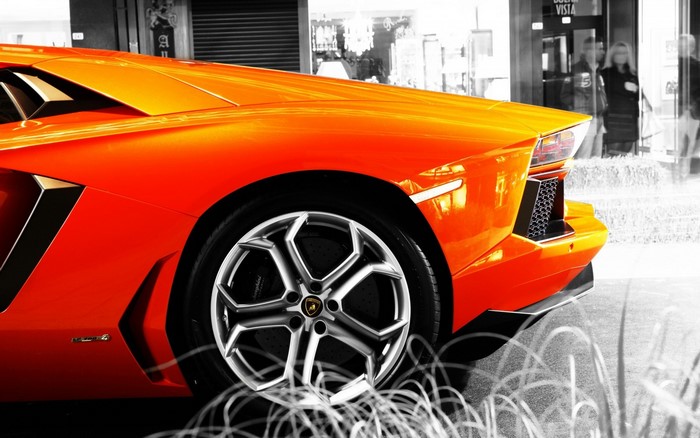 Orange Lamborghini Aventador parked outside a store