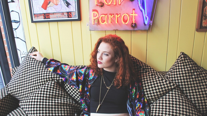 Jess Glynne sitting on a couch