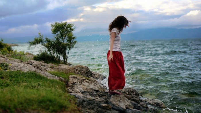 Woman in red skirt by the sea