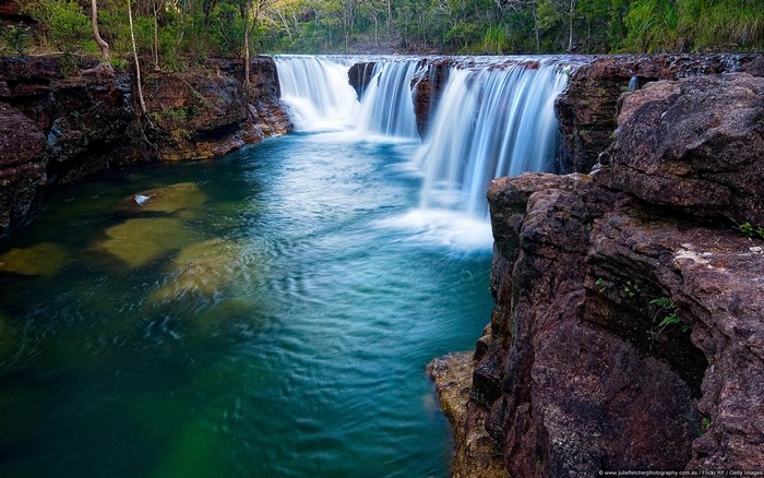 Waterfall cascading over rocks into a turquoise pool