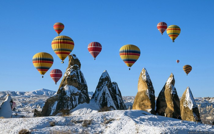 Hot air balloons over snowy mountains
