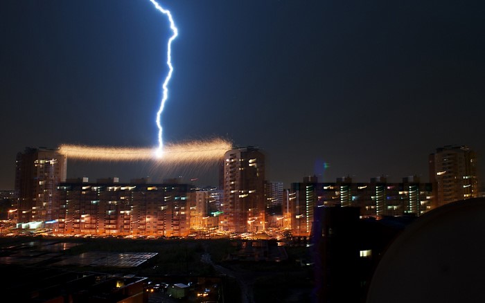Lightning strikes a city skyline at night