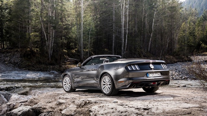 Gray Ford Mustang Convertible parked by a forest stream