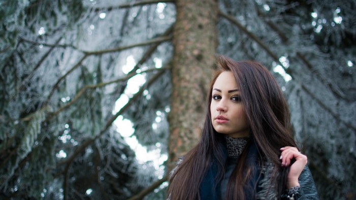 Woman with long brown hair in a winter forest