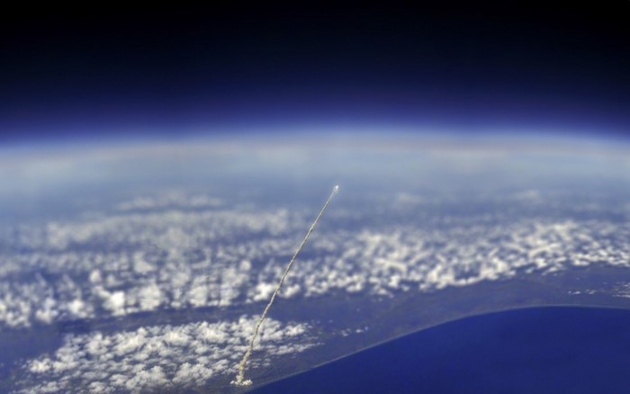 Rocket Launching into Space Over Earth's Atmosphere