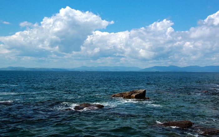 Ocean with clouds and distant mountains