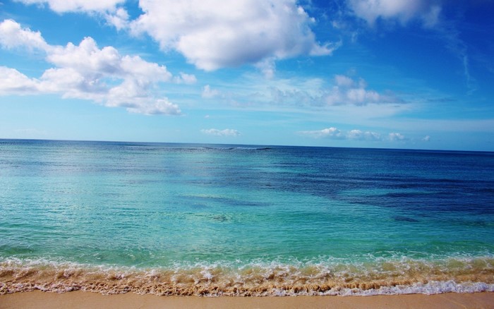 Sandy beach with turquoise ocean and blue sky