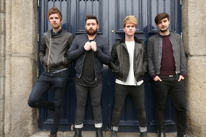 Kodaline band members standing in front of blue doors
