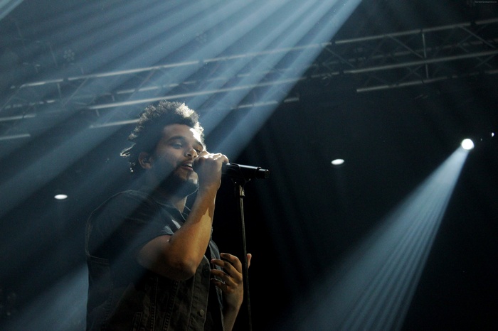 The Weeknd performing on stage with spotlights