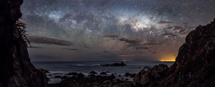 Milky Way over rocky coast at night