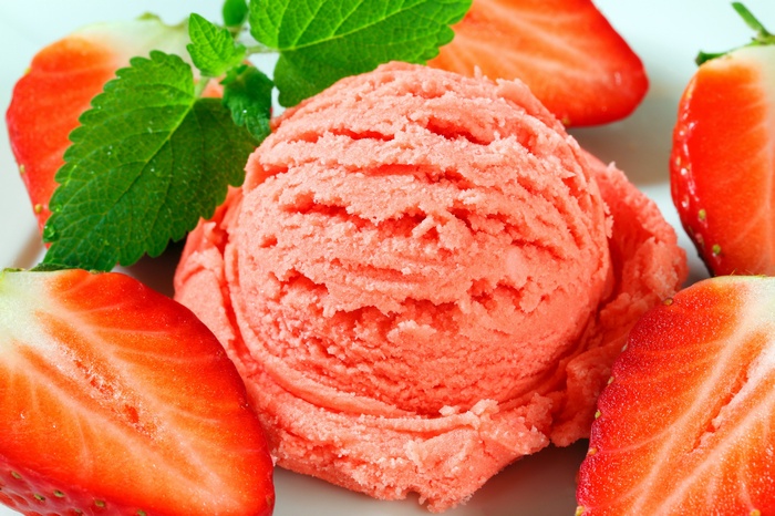 Strawberry ice cream scoop with fresh strawberries and mint