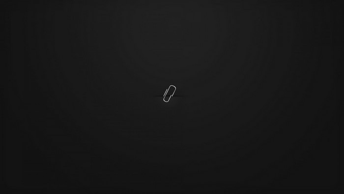 A single paperclip on a black background