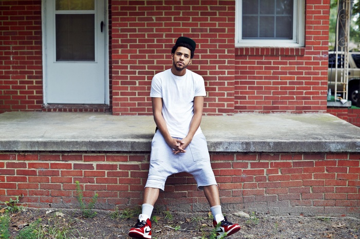 J. Cole sitting on a porch