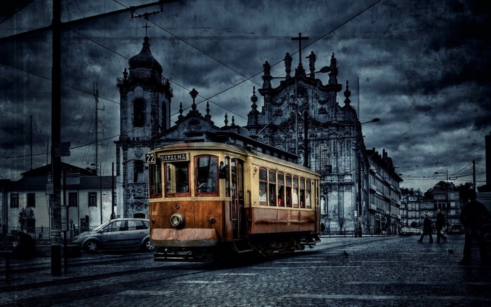 Vintage tram on a cobblestone street in front of a church