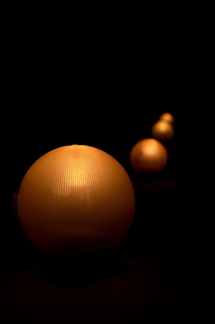 Row of illuminated spheres in darkness