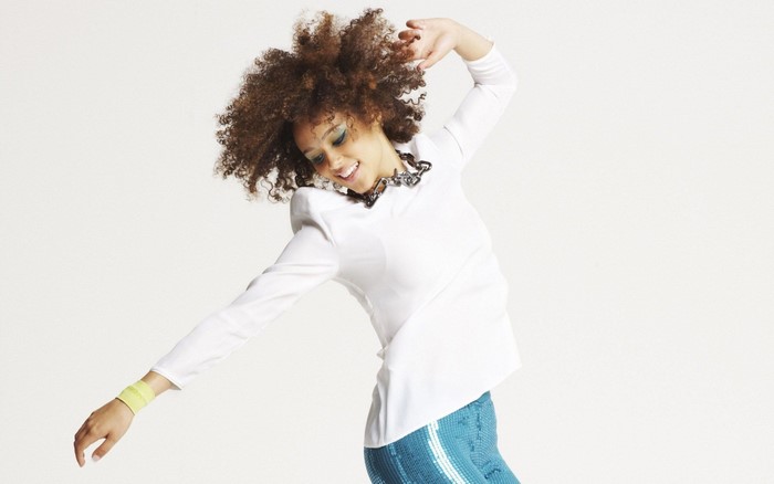 Nathalie Emmanuel dancing in white top and blue skirt