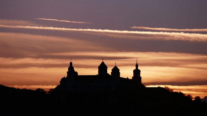 Castle silhouette against a sunset sky with clouds