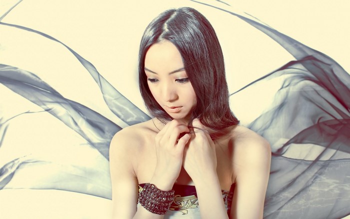 Model with long dark hair and flowing fabric