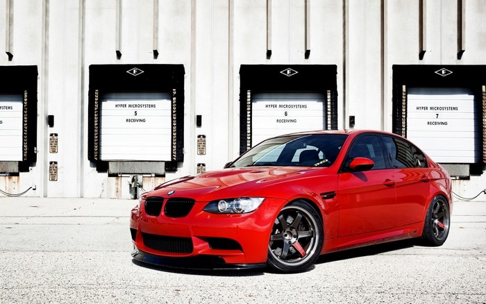 Red BMW M3 Sedan parked in front of loading docks
