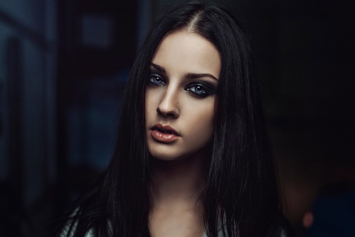 Portrait of a young woman with dark hair and blue eyes