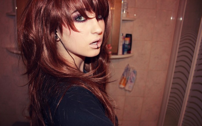 Woman with long red hair and piercings