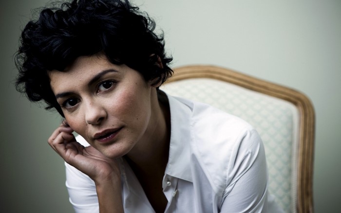 Woman with short dark hair wearing a white shirt
