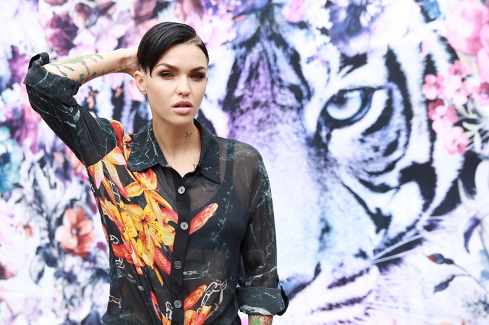 Ruby Rose posing in front of a tiger and floral print