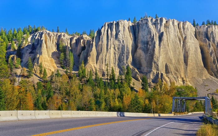 Roadside Hoodoos and Autumn Trees Under Blue Sky