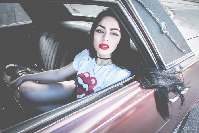 Woman with dark hair in a vintage car