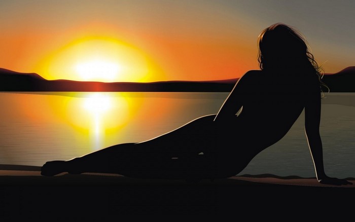 Silhouette of a woman at sunset over the water