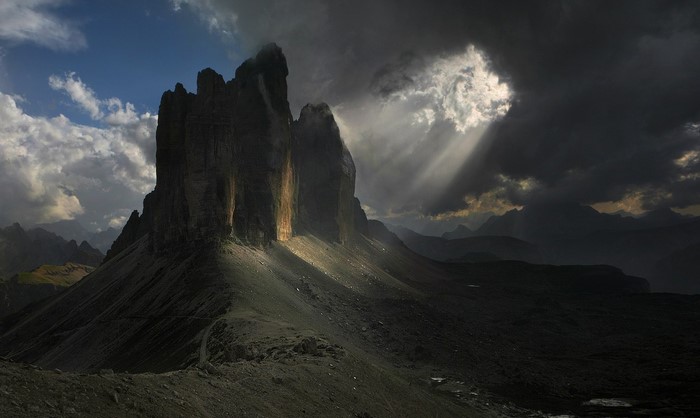 Sunlight Beaming Through Clouds Over Dolomites Mountains