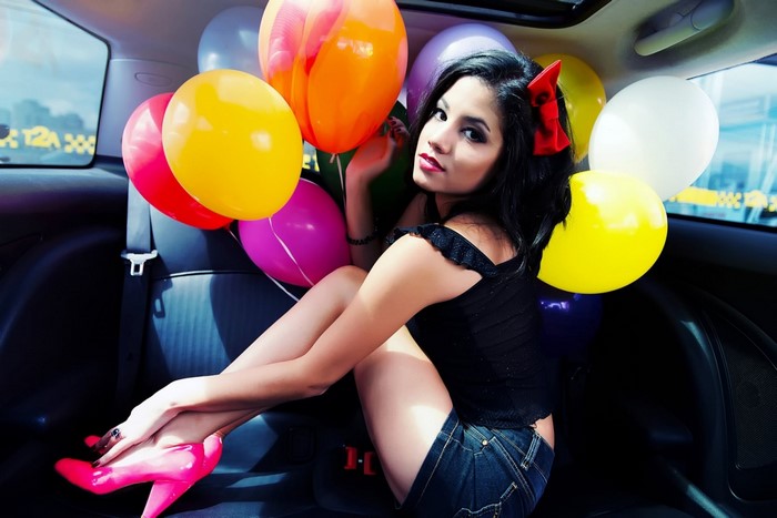Woman in car with balloons